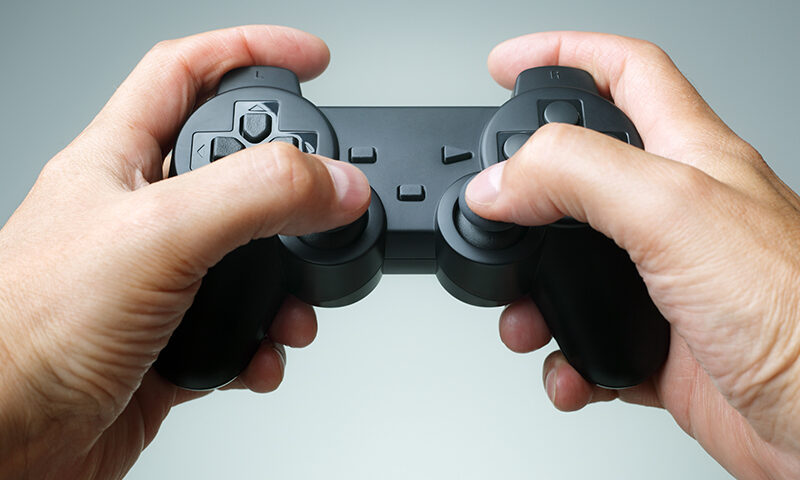 Video game console controller in gamer hands